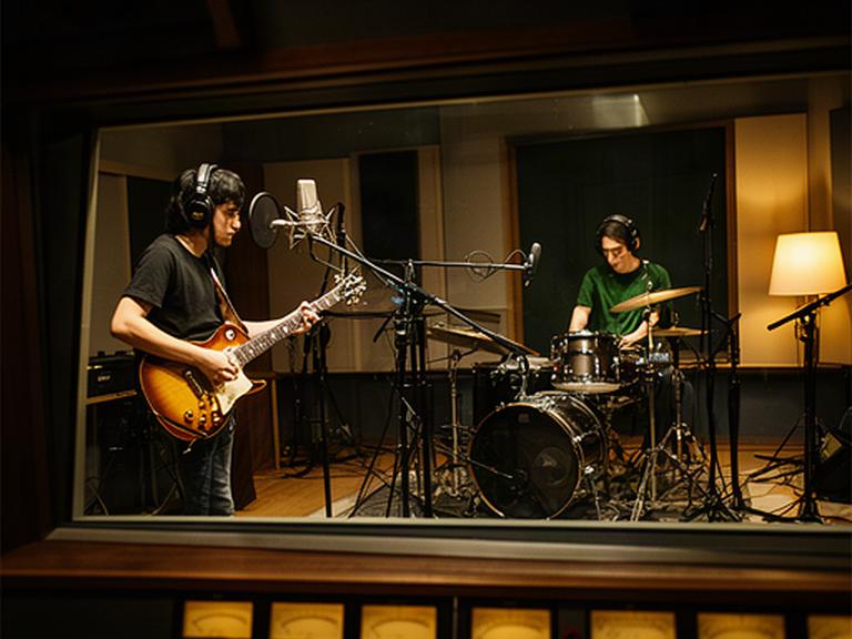 青森の録音スタジオでギターとドラムを同時に演奏するバンドの収録風景